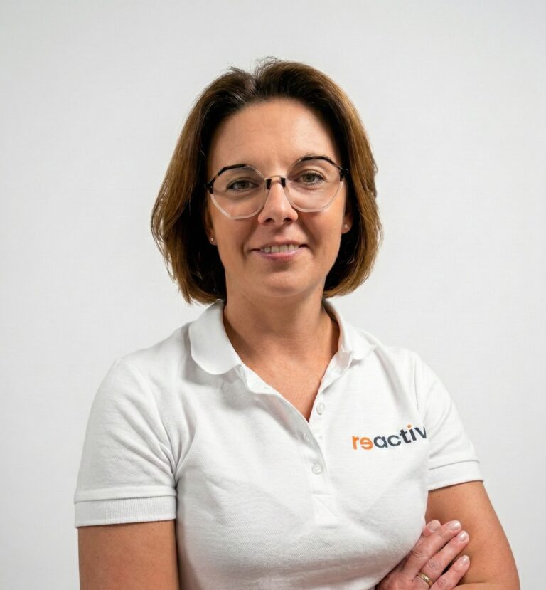 Fizjoterapeutka Karolina z Reactive Warszawa Ursus, specjalistka rehabilitacji ortopedycznej z ponad 15-letnim doświadczeniem, uśmiecha się w gabinecie.